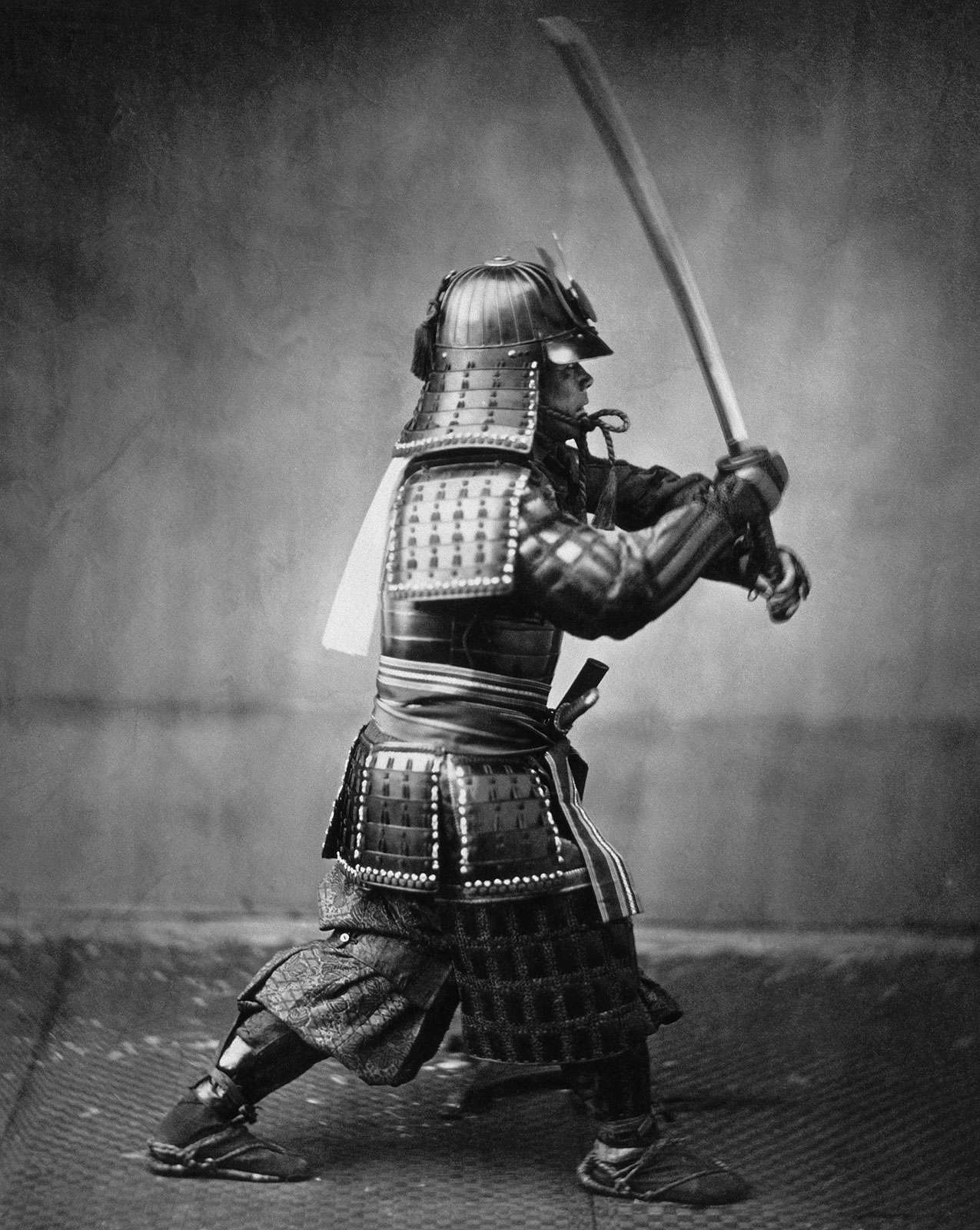 Samurai with sword,
        hand-coloured 
        photograph, 19th century